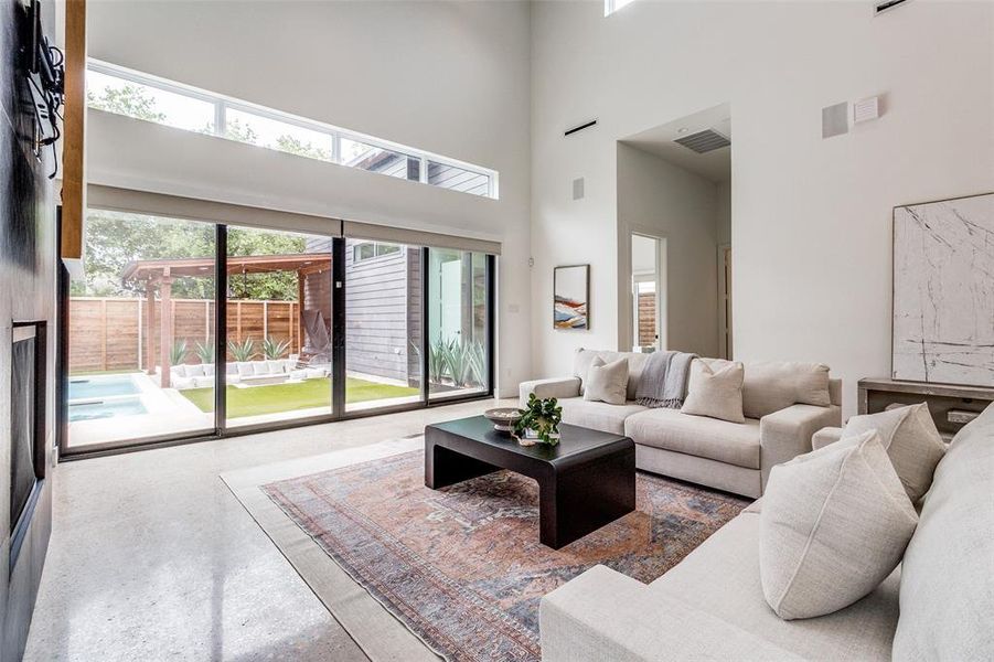 Living room with a towering ceiling and concrete flooring