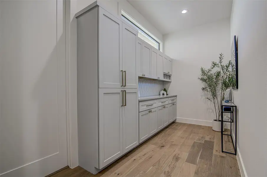 Bar with light wood-type flooring, recessed lighting, and baseboards Bar with light wood-type flooring, recessed lighting, and baseboards
