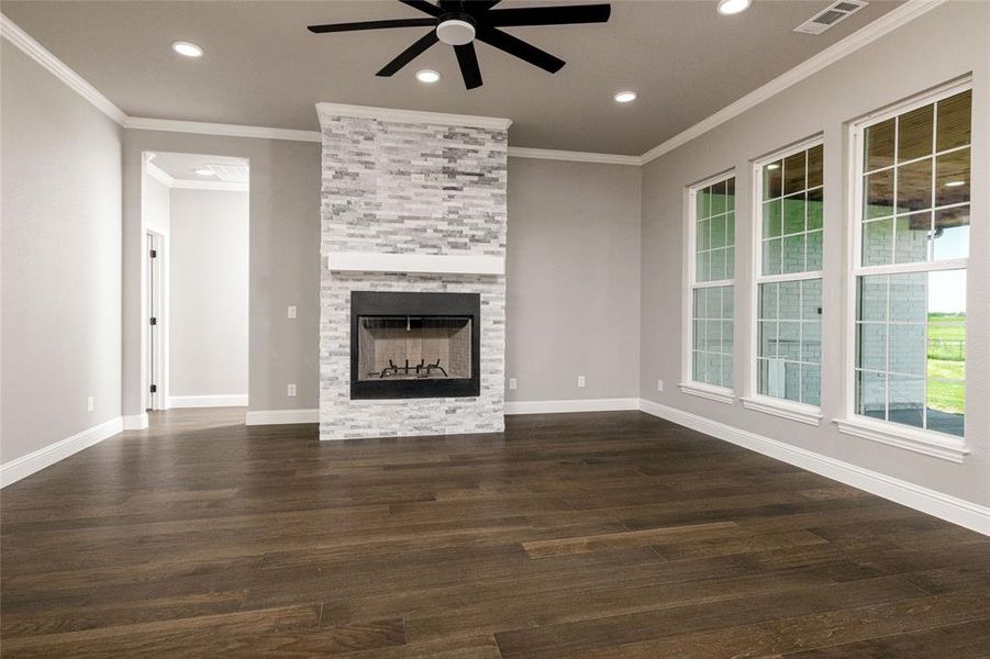 Unfurnished living room with recessed lighting, dark wood finished floors, ceiling fan, visible vents, and a fireplace Unfurnished living room with recessed lighting, dark wood finished floors, ceiling fan, visible vents, and a fireplace