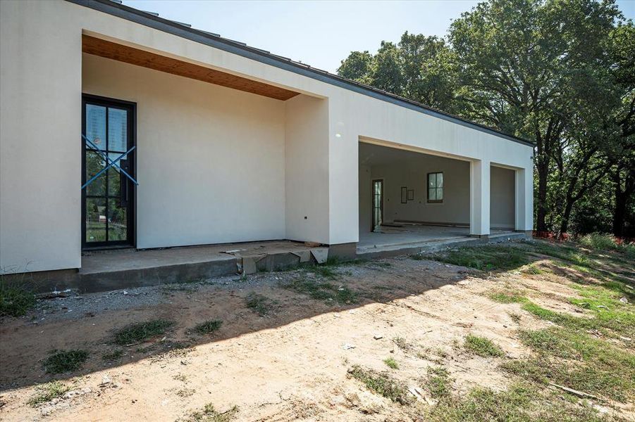 Side of home with an oversized 3 car garage and side entrance with covered patio.