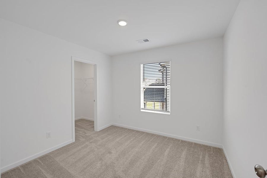 A room with a window and a carpet.