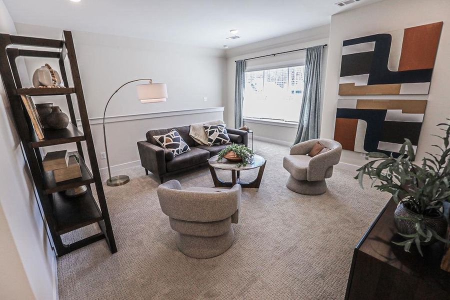 Carpeted living area featuring baseboards