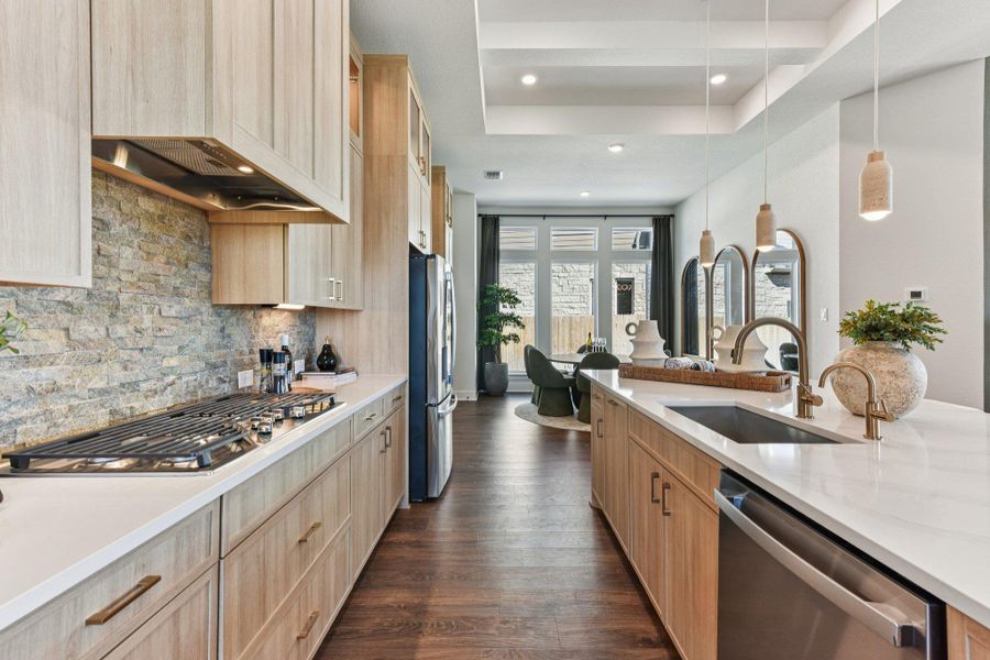 Rich wood floors anchor this kitchen workspace beneath a custom recessed ceiling detail.