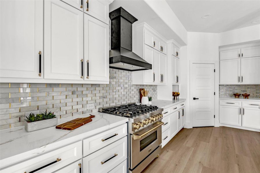 At the heart of the kitchen is a 36-inch ZLINE Autograph Edition gas range with six burners, designed for both beauty and function.