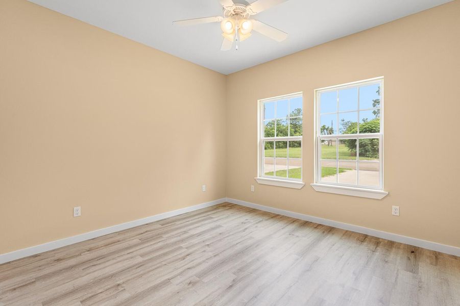 Spare room with light wood finished floors and ceiling fan