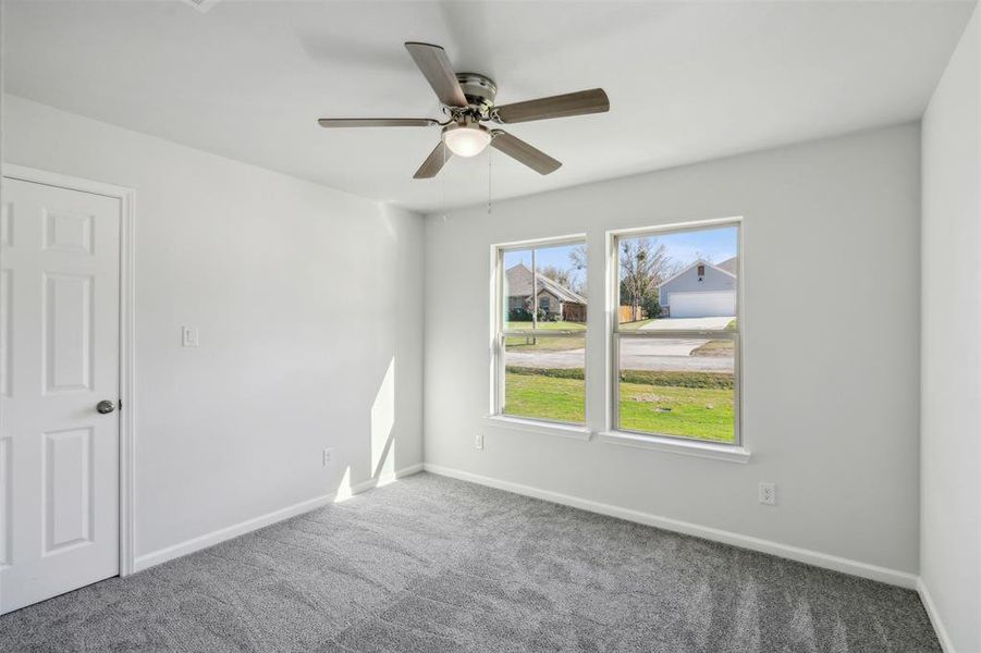 Empty room with carpet flooring and ceiling fan