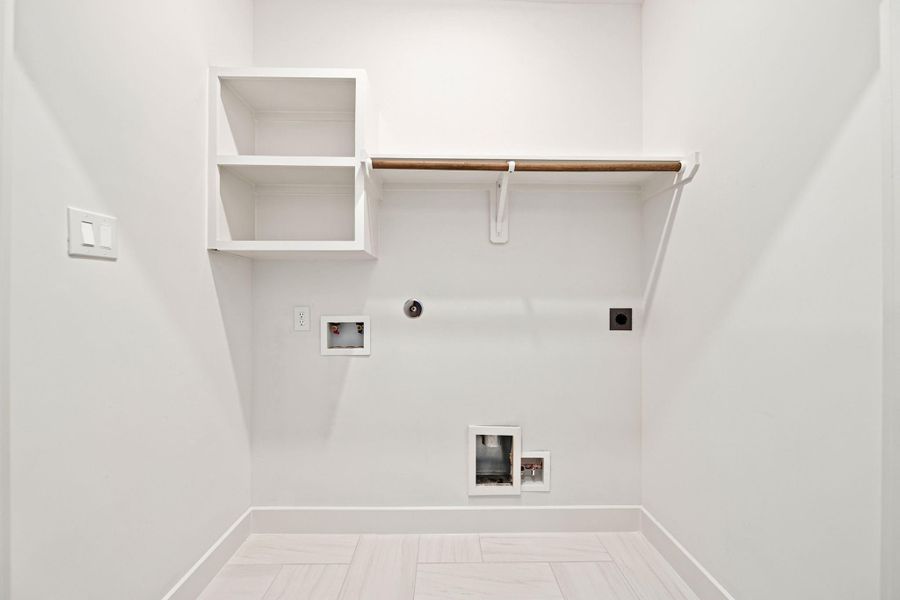 A dedicated laundry alcove keepshousehold routines organized withwasher and dryer connections,built-in shelving, a hanging rod,and easy-care tile flooring. Thecompact yet functional designoffers a convenient place forsupplies, folded linens, andhanging garments whilemaintaining a clean, streamlinedappearance.