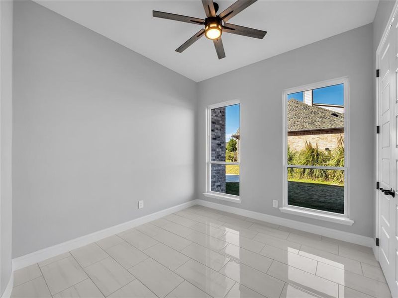 Spare room with light tile patterned floors and ceiling fan Spare room with light tile patterned floors and ceiling fan