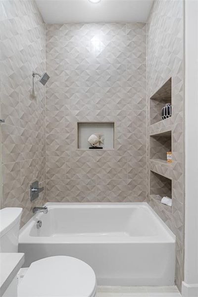 Full bathroom featuring tiled shower / bath, vanity, and toilet