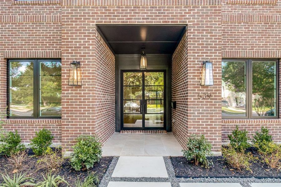 Brick facade with dark-framed windows and a prominent entry Brick facade with dark-framed windows and a prominent entry