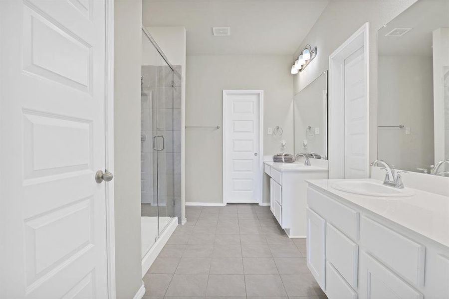 Bathroom with tile patterned flooring, vanity, and walk in shower