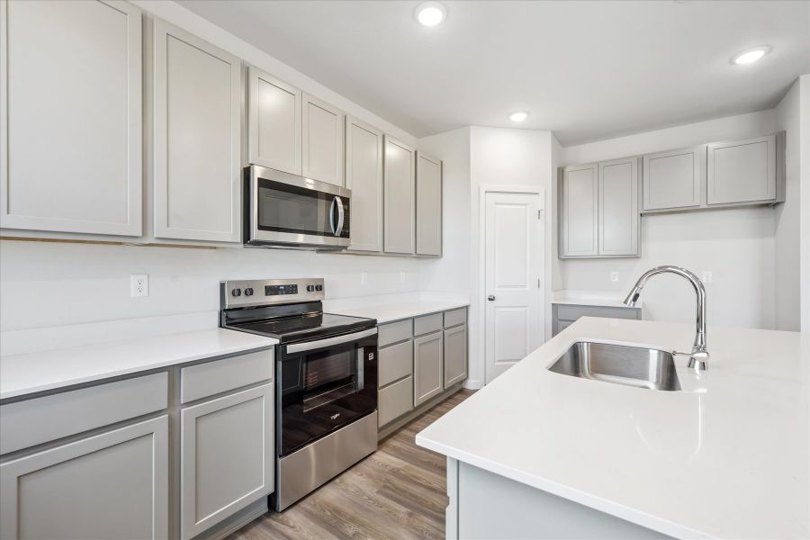A kitchen with white cabinets.