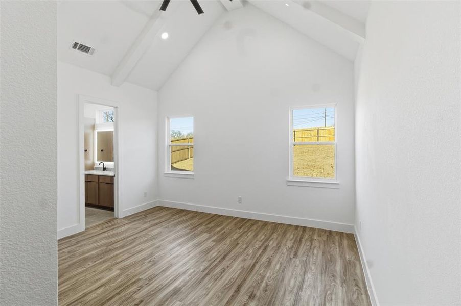 Unfurnished bedroom with light wood-style flooring, ensuite bathroom, ceiling fan, and recessed lighting