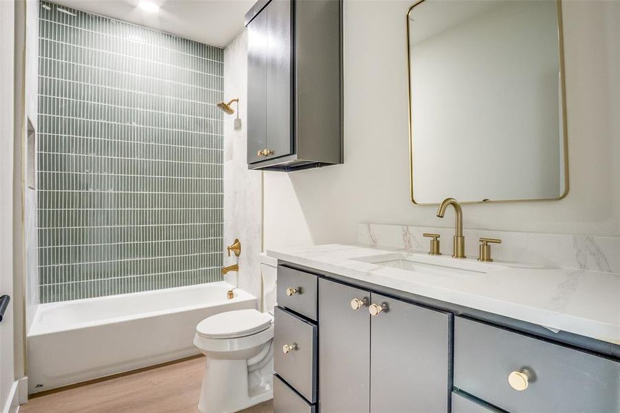 Bathroom featuring vanity, shower / tub combination, and wood finished floors