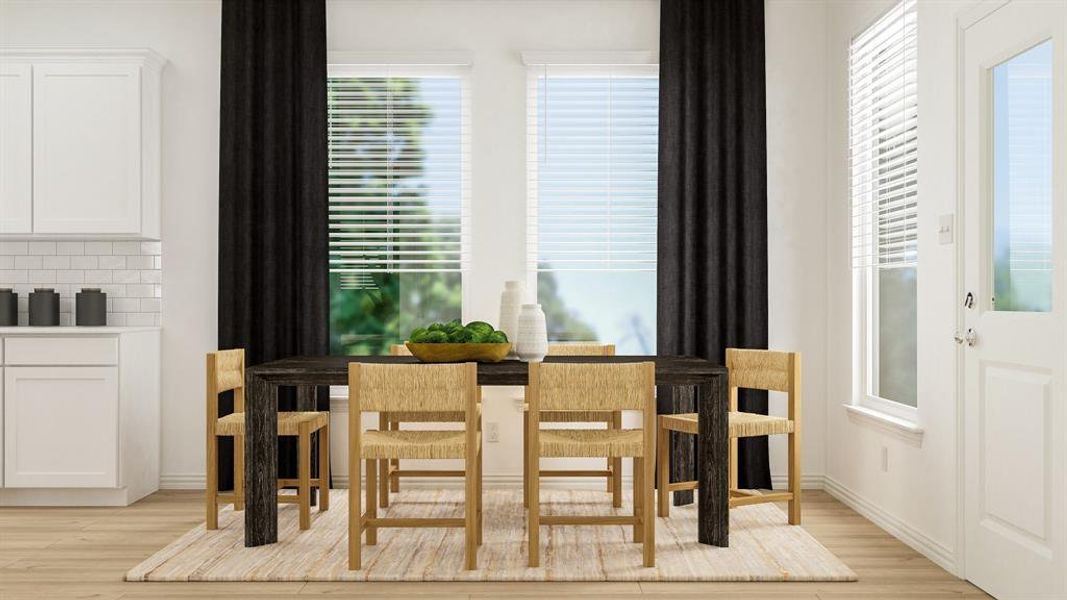 Dining room with a healthy amount of sunlight and light hardwood / wood-style floors