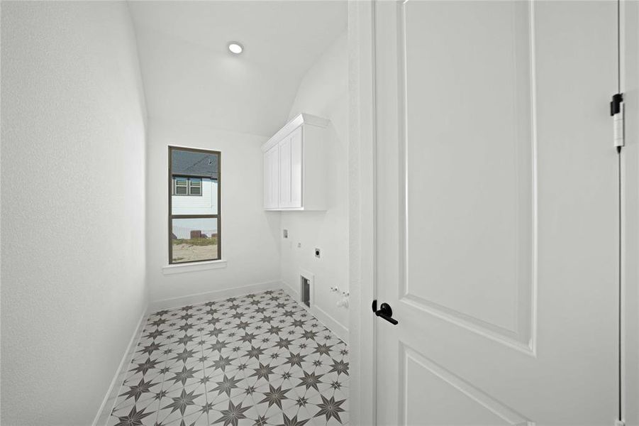 Laundry area featuring gas dryer hookup, vaulted ceiling, cabinet space, hookup for an electric dryer, and washer hookup Laundry area featuring gas dryer hookup, vaulted ceiling, cabinet space, hookup for an electric dryer, and washer hookup