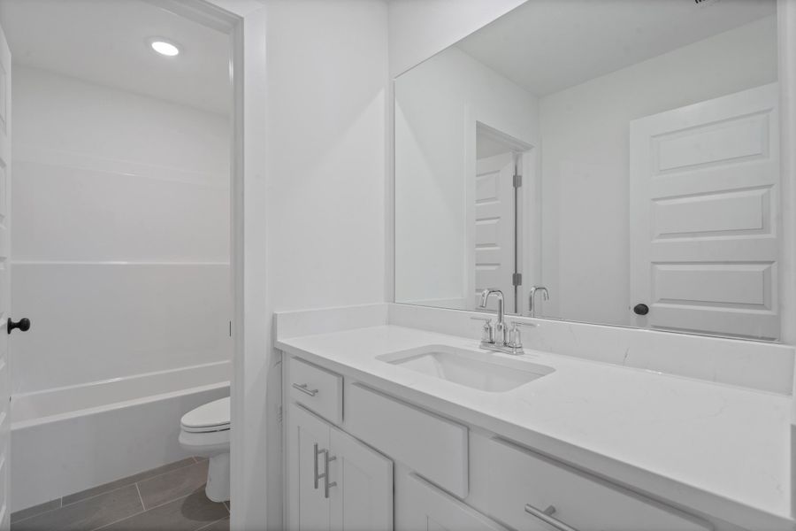 White vanity with shaker-style cabinetry, an integrated sink, and a chrome faucet