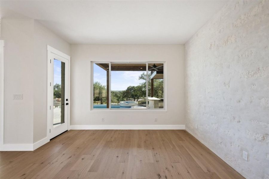 Hardwood floors and a wide window with a pool view make this room an inviting oasis. Hardwood floors and a wide window with a pool view make this room an inviting oasis.