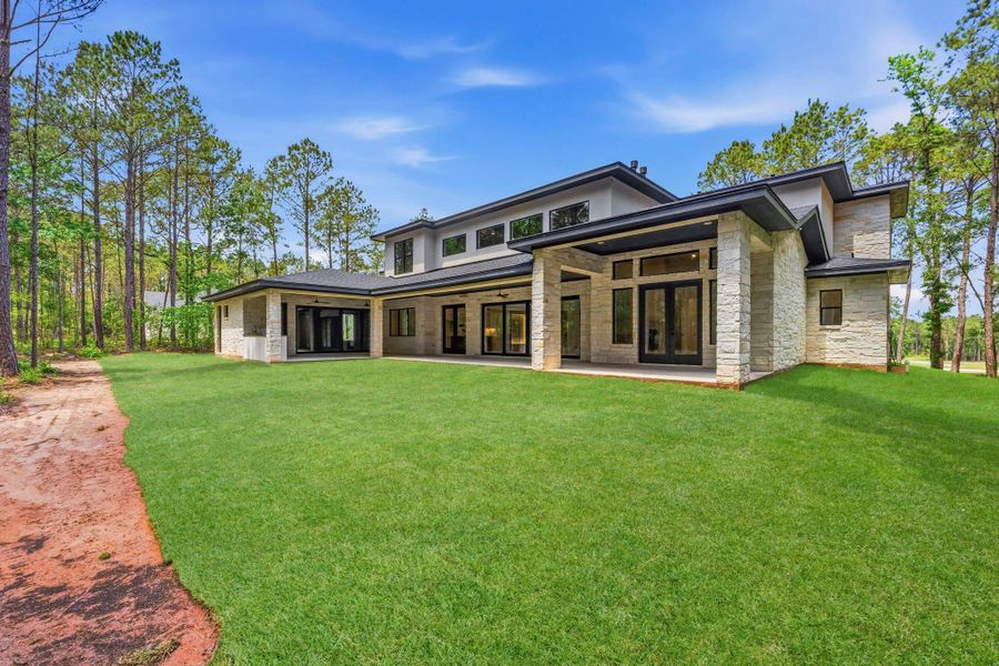 Set on just over 1.1 ACRES, the rear elevation showcases the home's IMPRESSIVE scale and seamless indoor-outdoor living.