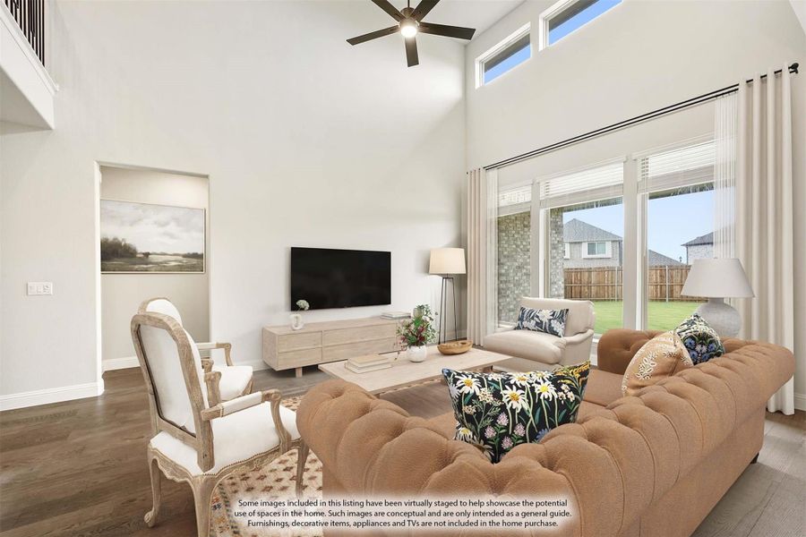 Living room with two-story ceiling, ceiling fan, large windows, hardwood floors, and sliding glass doors to backyard Living room with two-story ceiling, ceiling fan, large windows, hardwood floors, and sliding glass doors to backyard