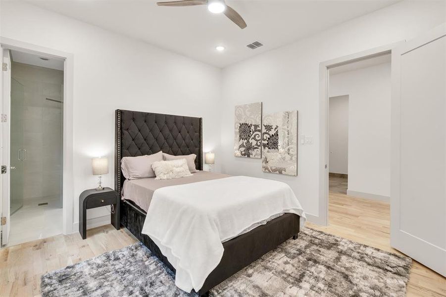 Bedroom with ceiling fan, light hardwood / wood-style flooring, and ensuite bath