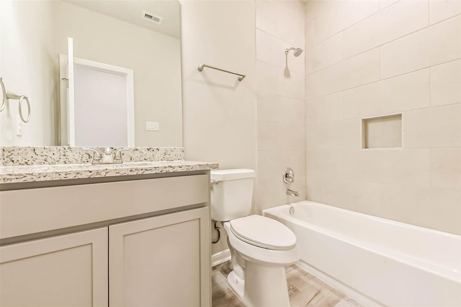 The secondary bathroom features a shower and tub combo, quartz countertops, and vinyl plank flooring! The secondary bathroom features a shower and tub combo, quartz countertops, and vinyl plank flooring!