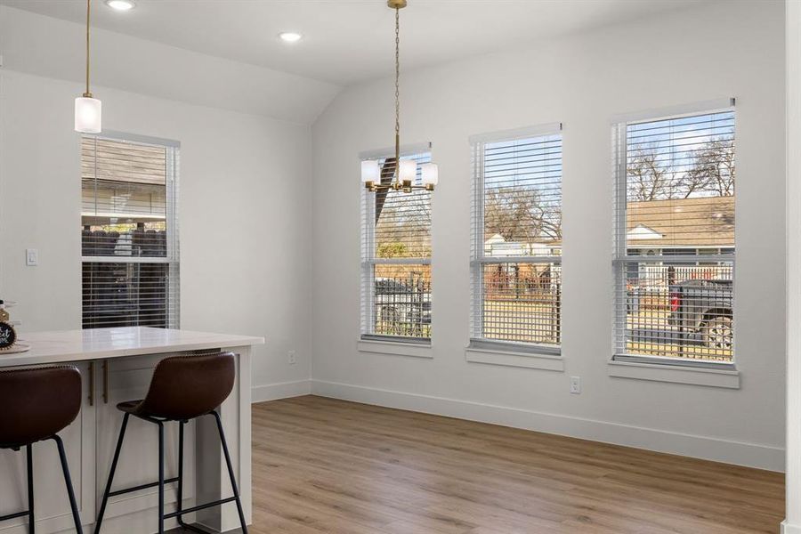 Kitchen with pendant lighting, sink, appliances with stainless steel finishes, white cabinets, and a center island with sink