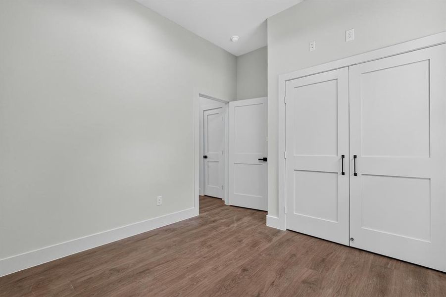 Wood-finish flooring anchors this space, featuring white trim and walls