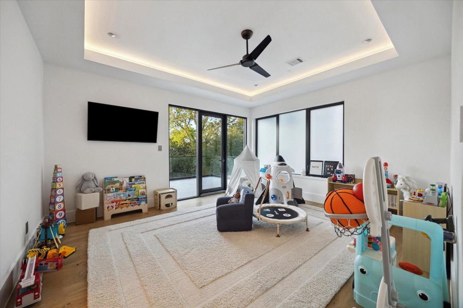 Ensuite secondary guest bedroom, currently being used as kid's play area. A sliding glass door offering convenient access to a private outdoor terrace.