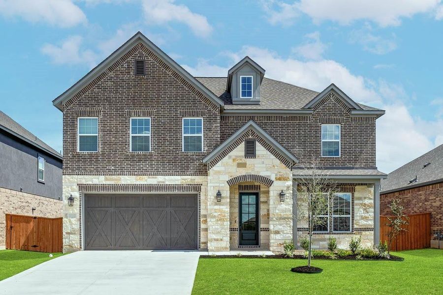 The Wilson plan at ShadowGlen is a beautiful two-story home  gorgeous cedar garage door, and lush front yard landscaping.