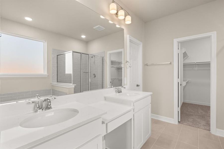 The en-suite bathroom offers a spa-like atmosphere with its elegant design, high end finishes, and tasteful lighting, creating a retreat within your own home.