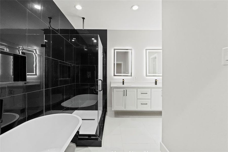 Bathroom featuring tile patterned floors, vanity, and shower with separate bathtub