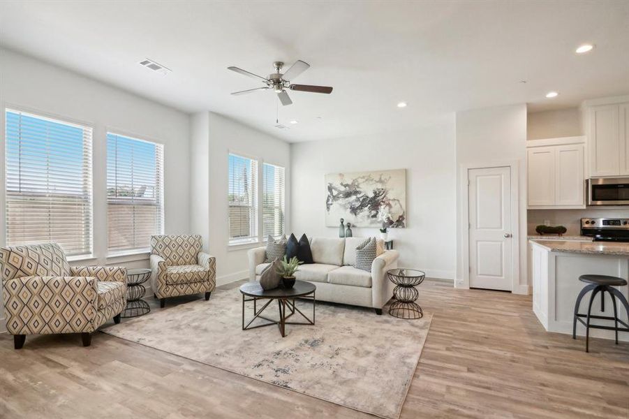 Living room with ceiling fan and light hardwood / wood-style flooring