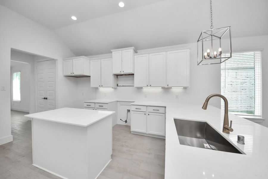 Step into a dream realized with this generously spacious kitchen! A massive granite island takes center stage, complemented by high ceilings and soft-close cabinets. The granite countertops, stainless steel appliances, sleek tile backsplash, and recessed lighting complete the elegant design.