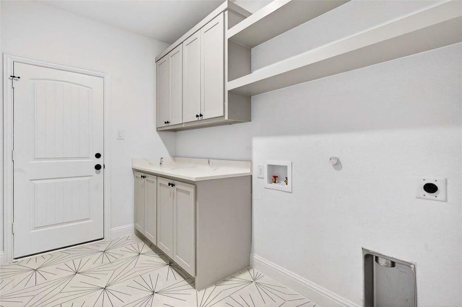 Washroom featuring hookup for a gas dryer, washer hookup, cabinet space, and hookup for an electric dryer