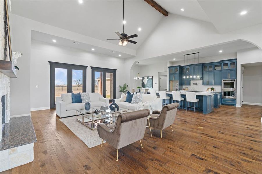 Living room with ceiling fan, a fireplace, beamed ceiling, high vaulted ceiling, and dark hardwood / wood-style flooring
