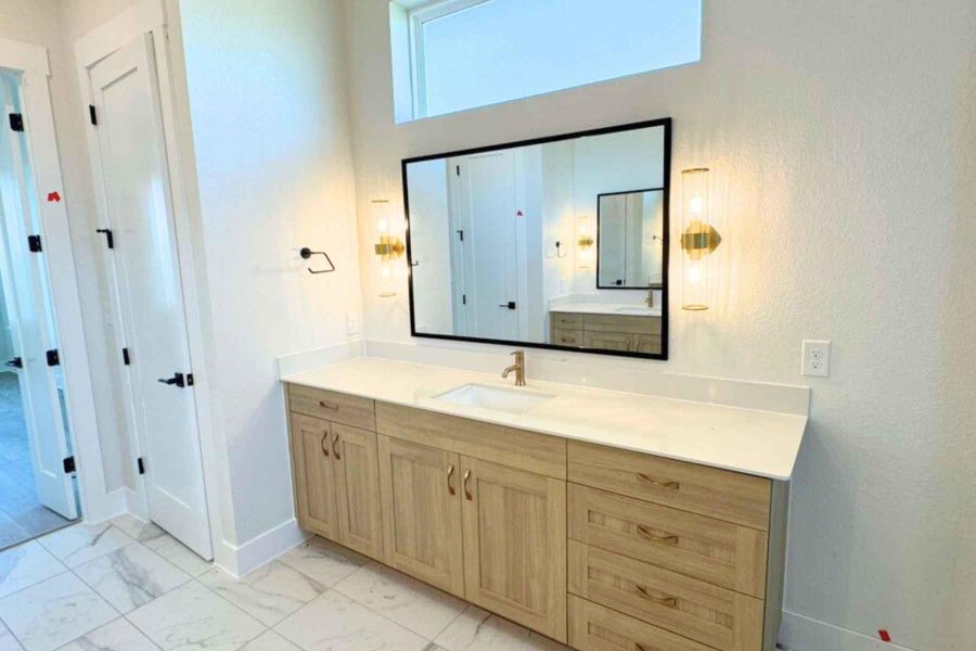 Full bath with vanity and light marble finish flooring