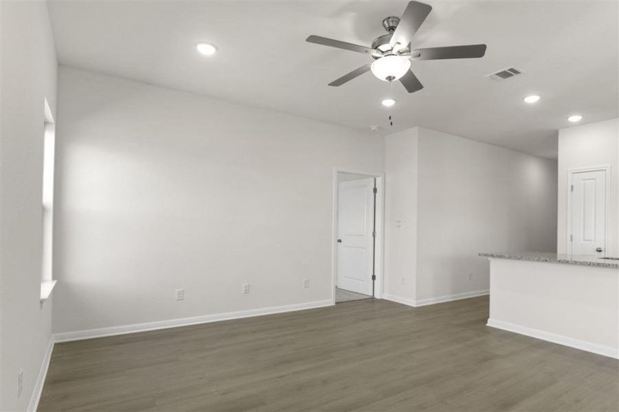 Empty room with ceiling fan, recessed lighting, dark wood-style flooring, visible vents, and baseboards