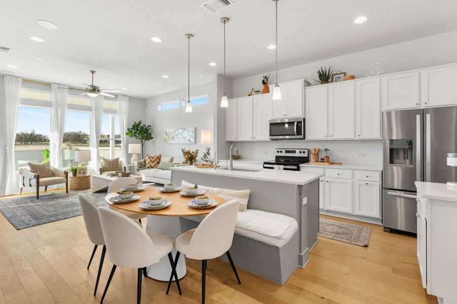 Kitchen with stainless steel appliances, light countertops, light wood-style flooring, backsplash, and recessed lighting Kitchen with stainless steel appliances, light countertops, light wood-style flooring, backsplash, and recessed lighting