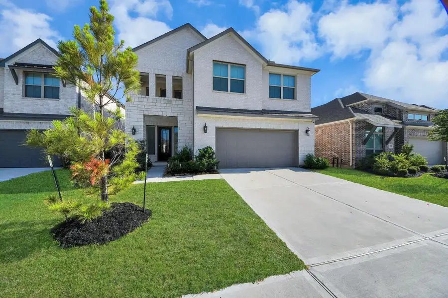 This is a modern, two-story home with a light brick exterior and a two-car garage. It has a well-maintained front lawn and a small tree, giving the property a clean and inviting appearance. This is a modern, two-story home with a light brick exterior and a two-car garage. It has a well-maintained front lawn and a small tree, giving the property a clean and inviting appearance.