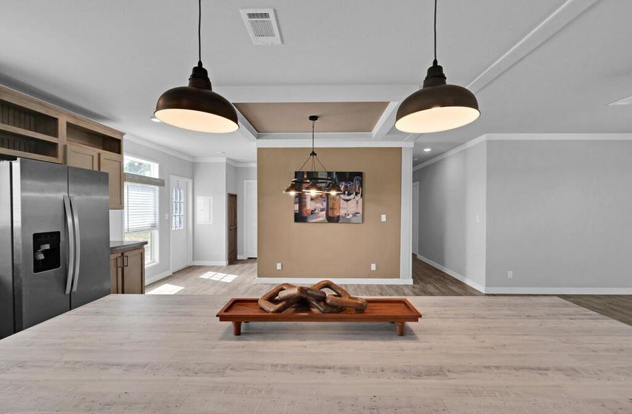 Dining area featuring coffered ceiling, light wood-style floors, beamed ceiling, and ornamental molding Dining area featuring coffered ceiling, light wood-style floors, beamed ceiling, and ornamental molding