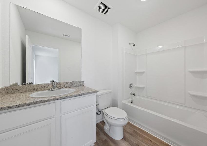 A shower/tub combination and a spacious vanity in the master bathroom