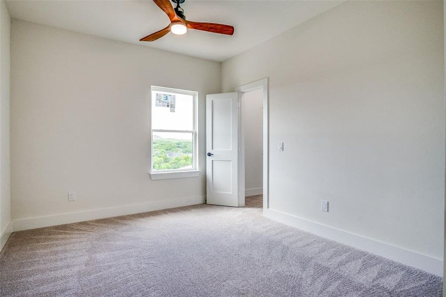 Unfurnished room with ceiling fan and carpet floors