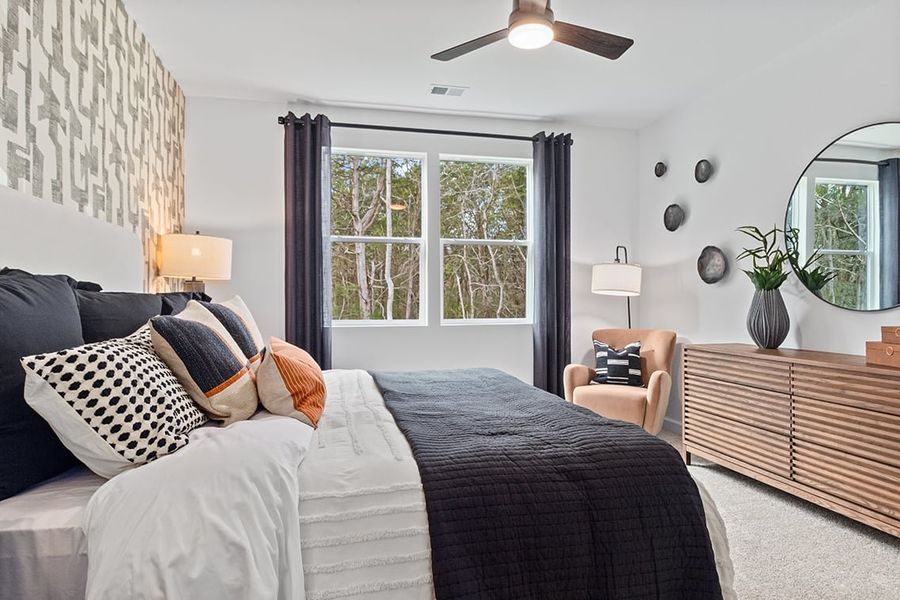 A bedroom with a bed and a fan.