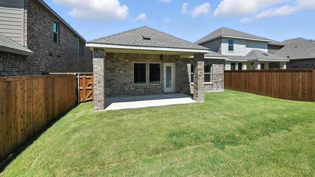 Back of house with brick siding, a shingled roof, and a fenced backyard Back of house with brick siding, a shingled roof, and a fenced backyard
