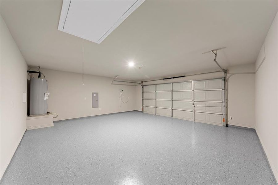 Garage featuring electric water heater and electric panel