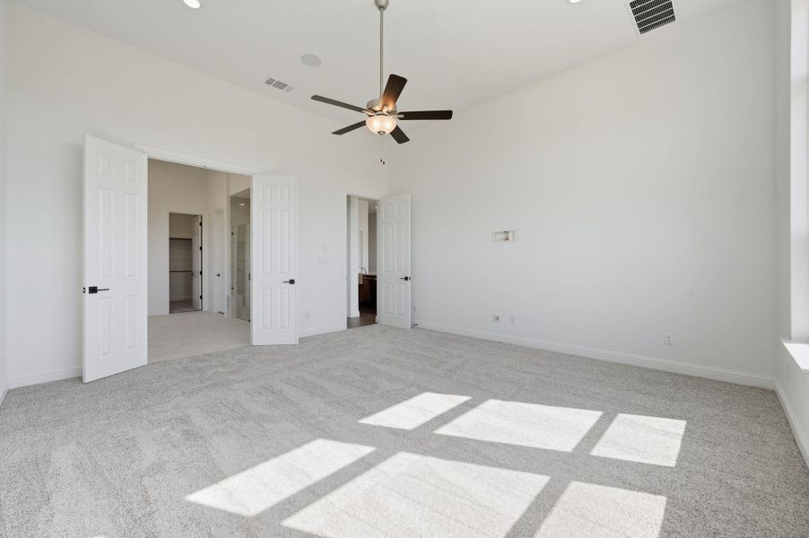 Unfurnished bedroom with light colored carpet and a ceiling fan