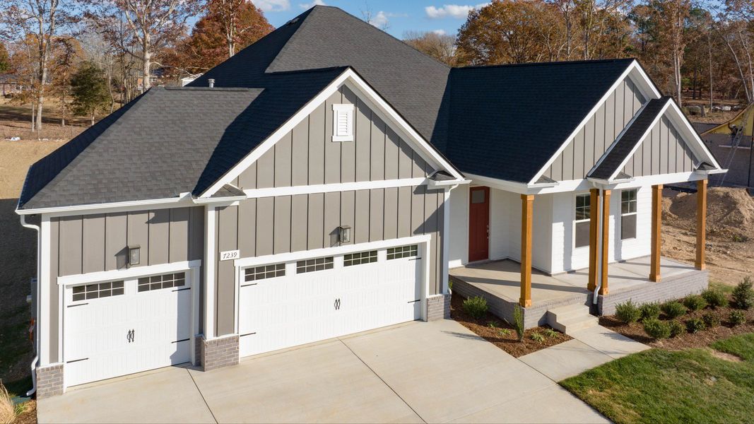 Exterior of home with white and gray siding and wood accent columns around covered front porch
