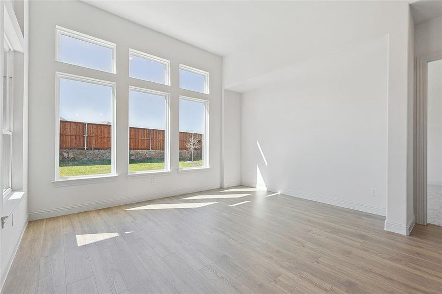 Spare room featuring light wood-style floors and baseboards