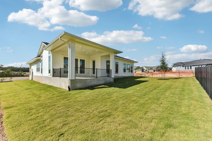 Rear view of house with stucco siding, a patio area, and a fenced backyard